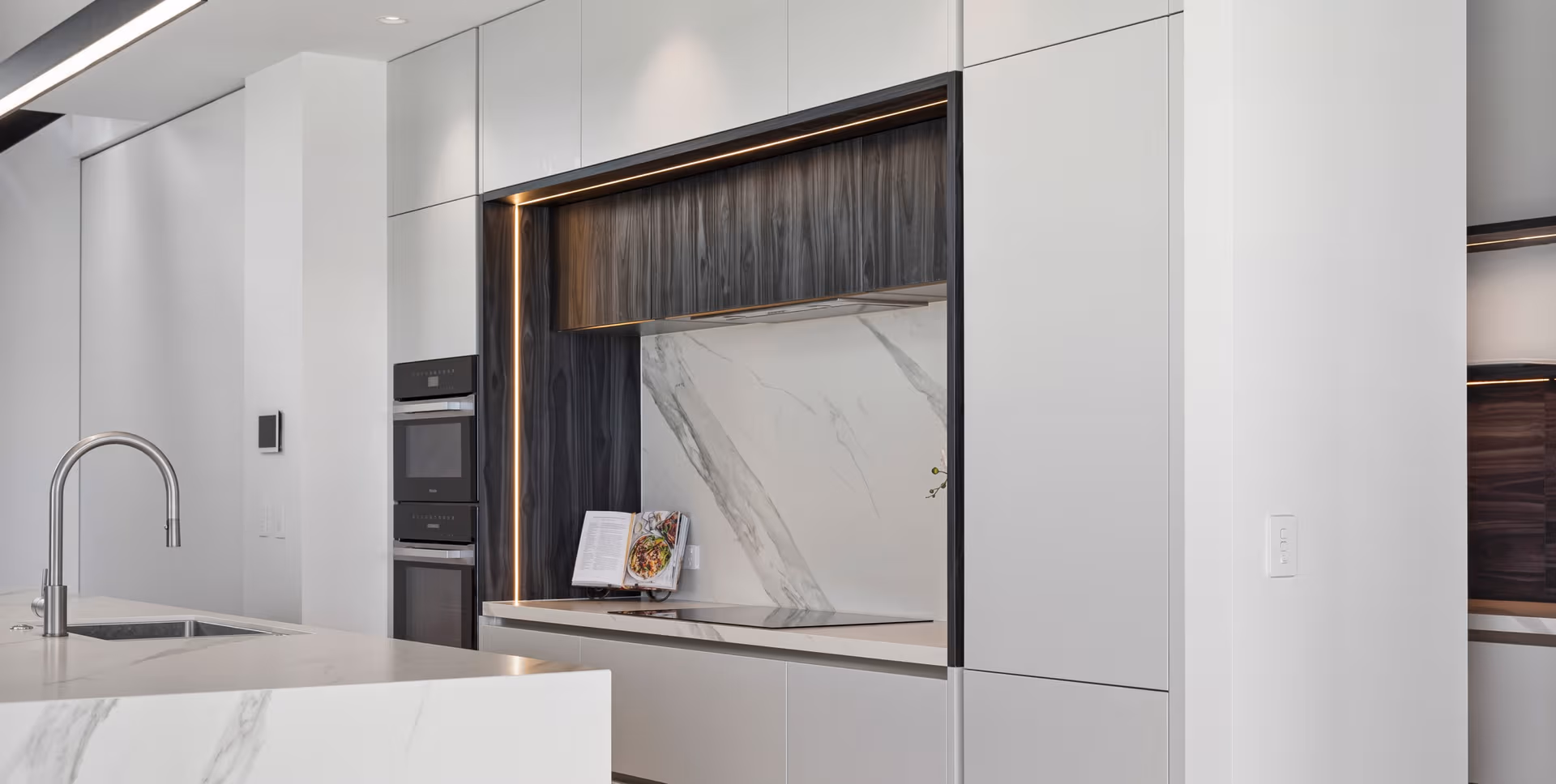 Clean, understated composition—white cabinetry, marble detailing and a touch of natural texture.