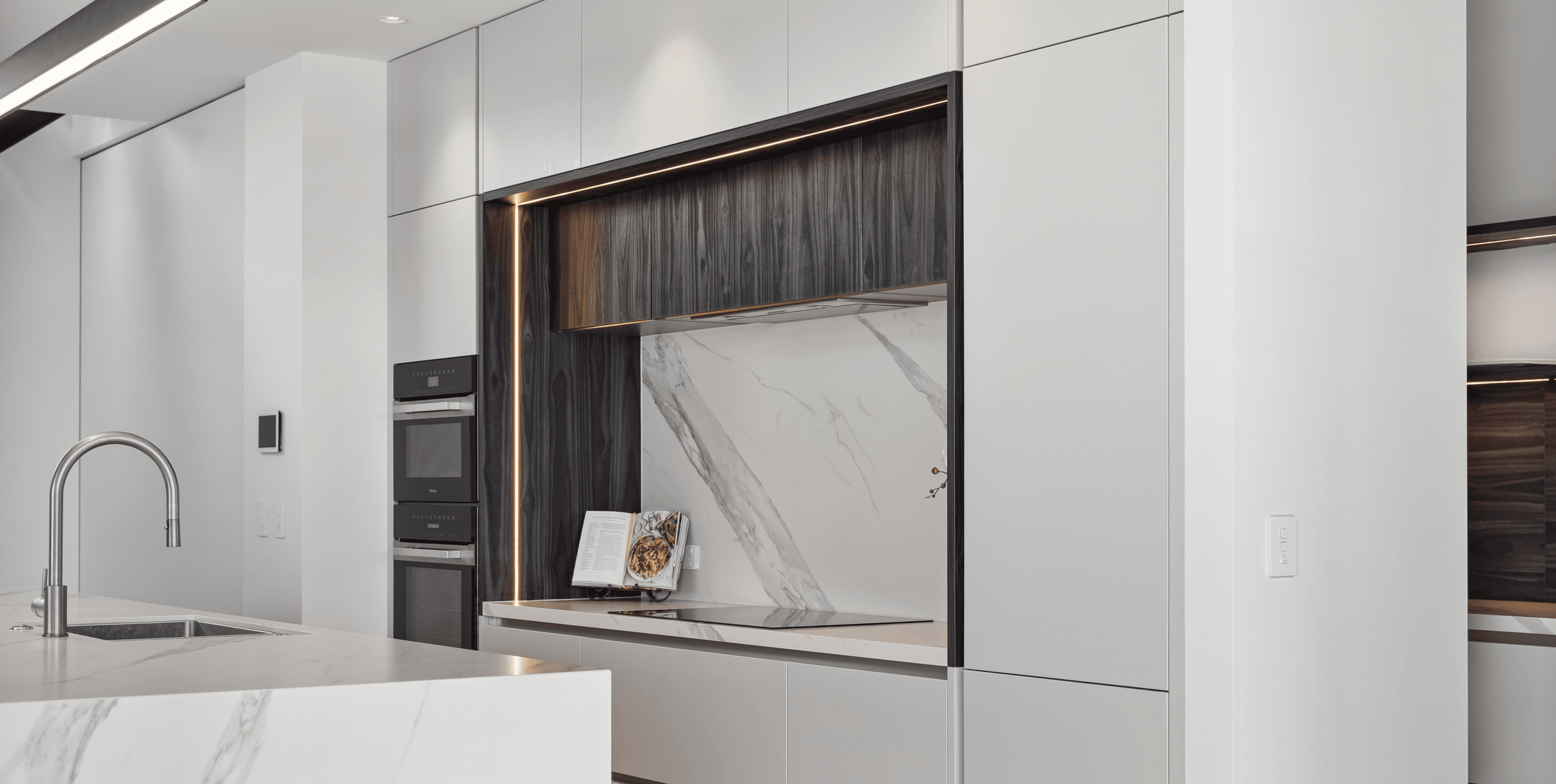 Clean, understated composition—white cabinetry, marble detailing and a touch of natural texture.