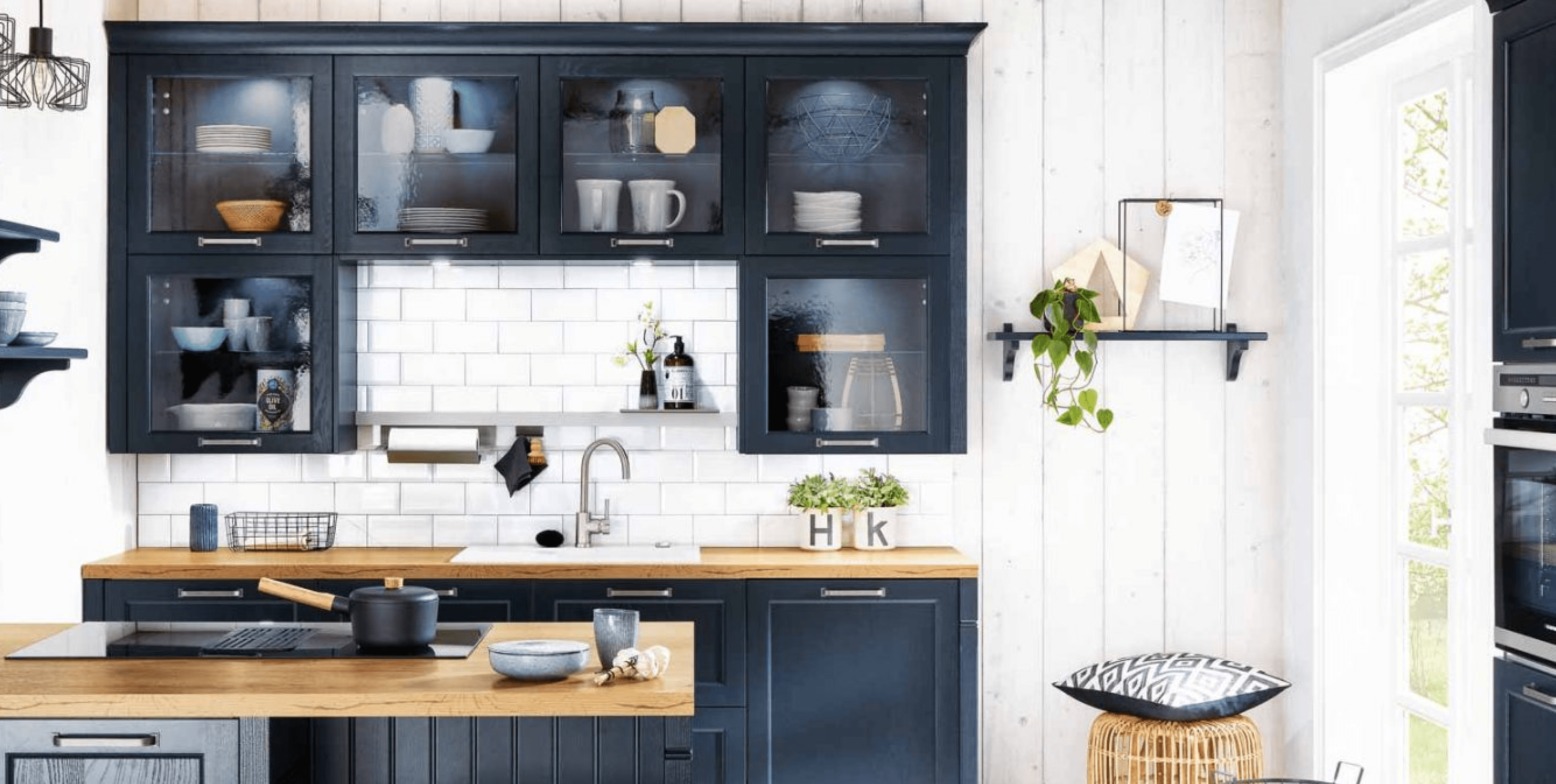 Deep blue cabinetry, glass displays and wood accents give this kitchen a relaxed yet refined character.