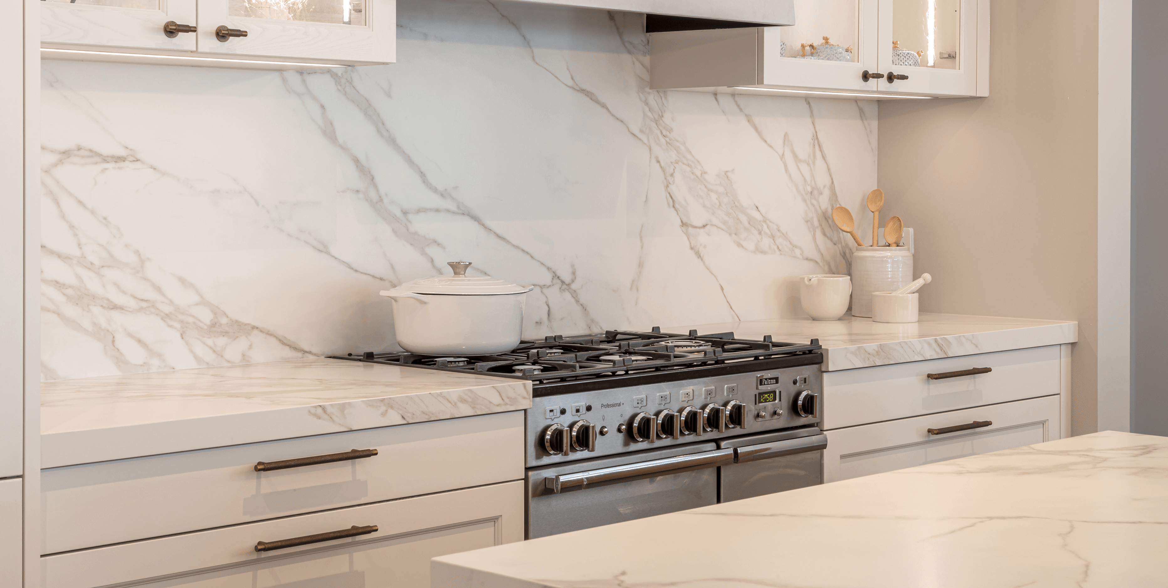 Shaker-style kitchen with marble benchtops, soft neutrals and subtle brass details for warmth.