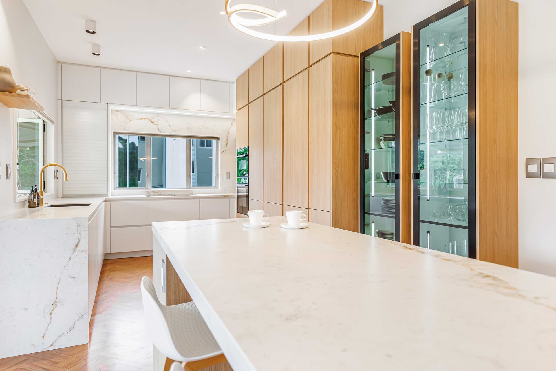 Contemporary kitchen with pale cabinetry and an integrated appliance wall