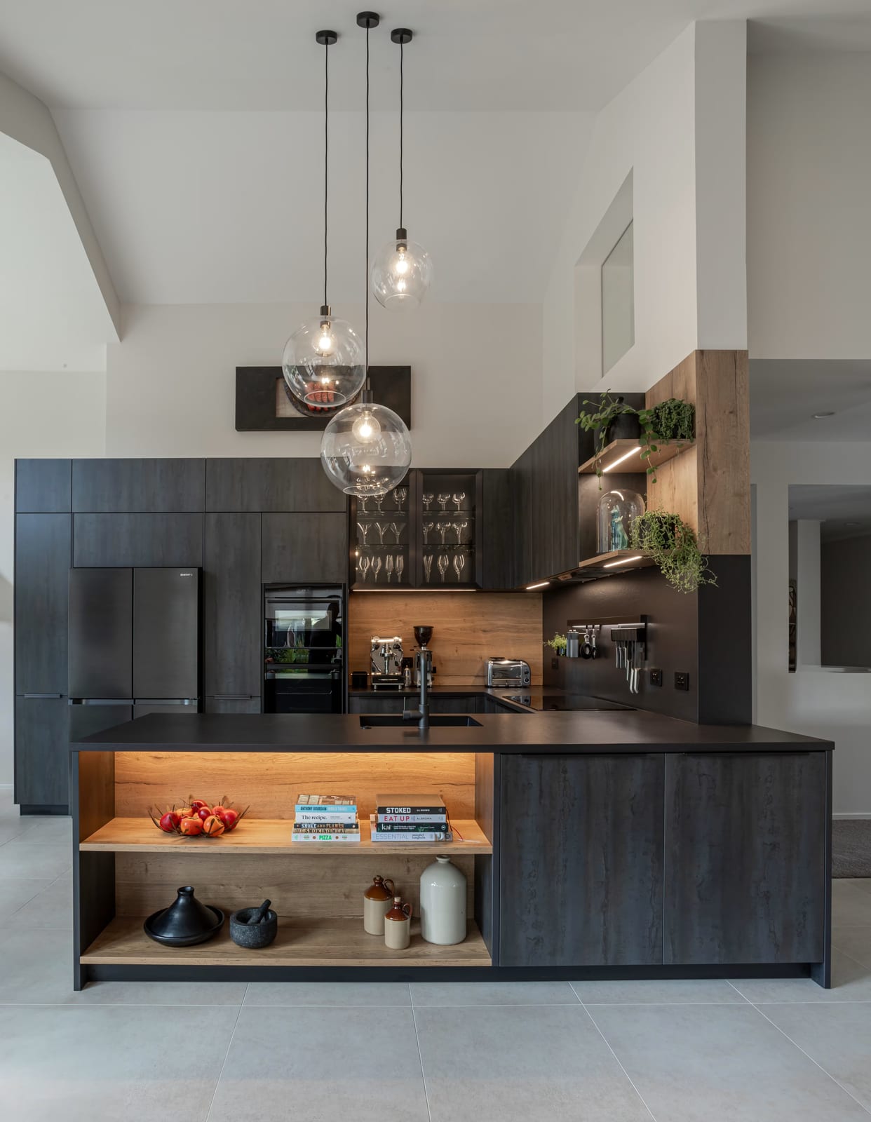 Charcoal kitchen with a coffee station, glass-fronted stemware cabinet and open island shelving