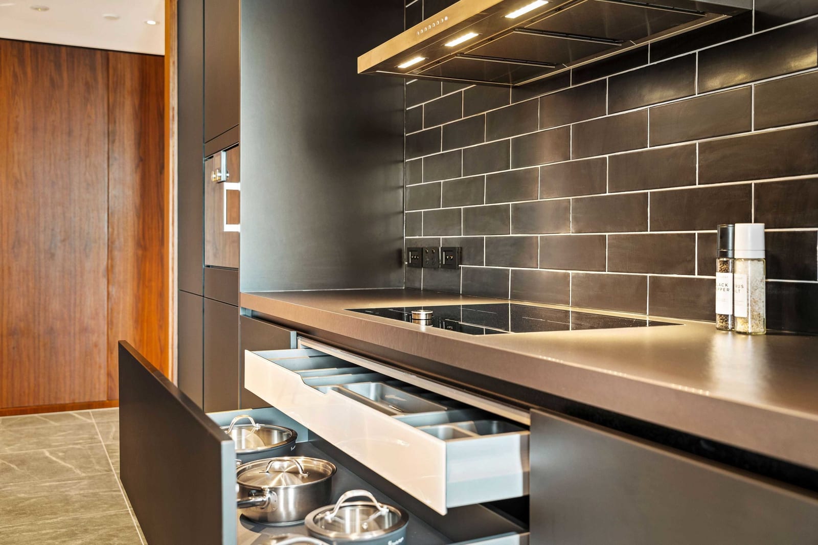 Internal cutlery organiser and deep pot drawer pulled out directly beneath the cooktop