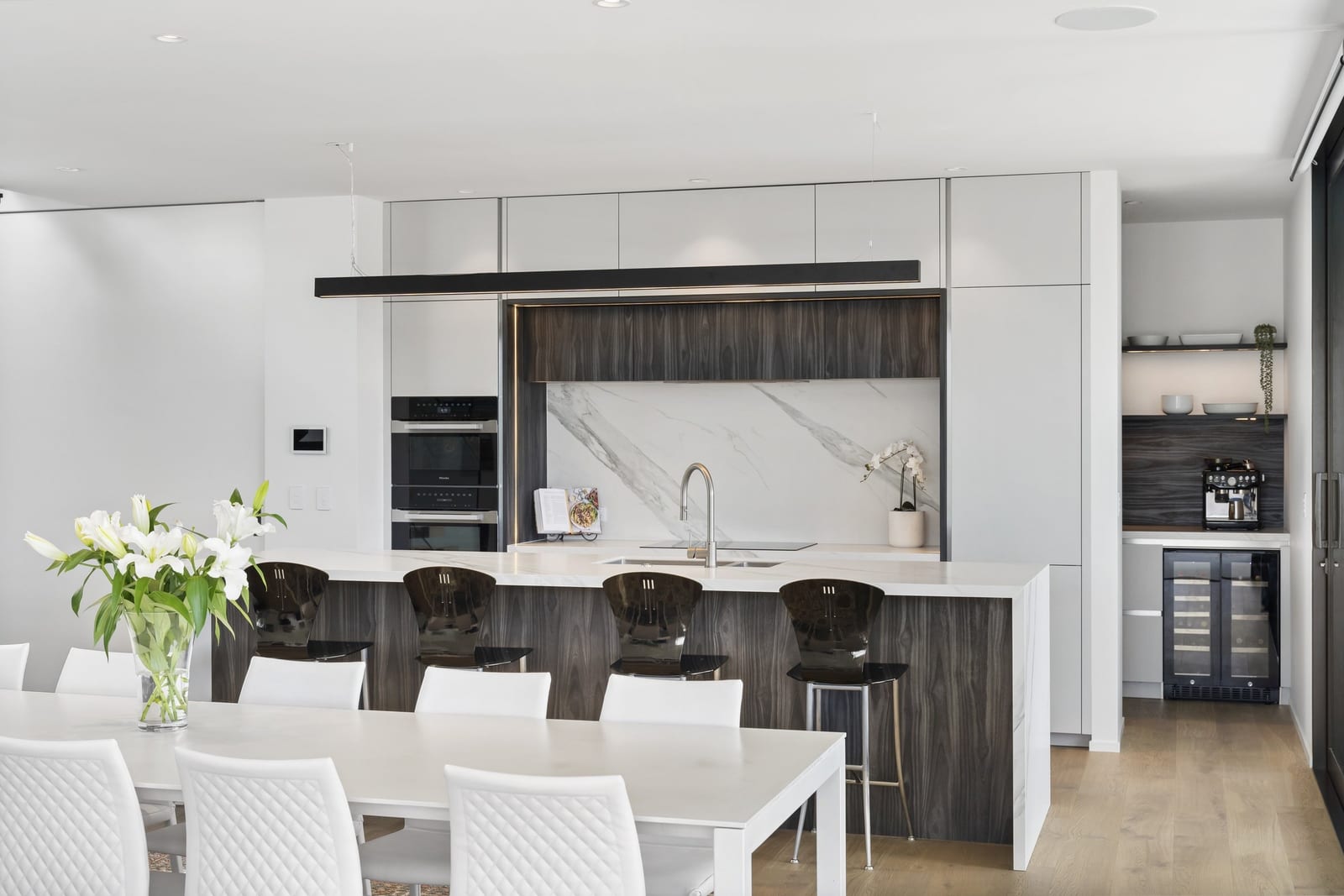 Open-plan dining and kitchen with a dark timber-look island and separate coffee alcove