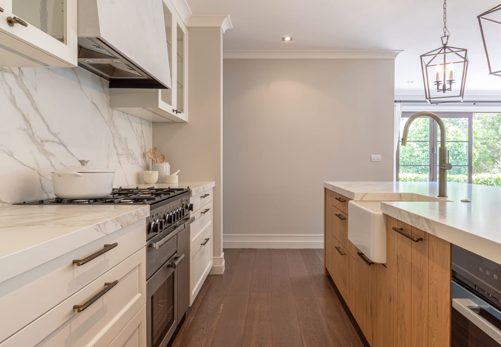 Clear working aisle between a range cooker and a timber island with a farmhouse sink