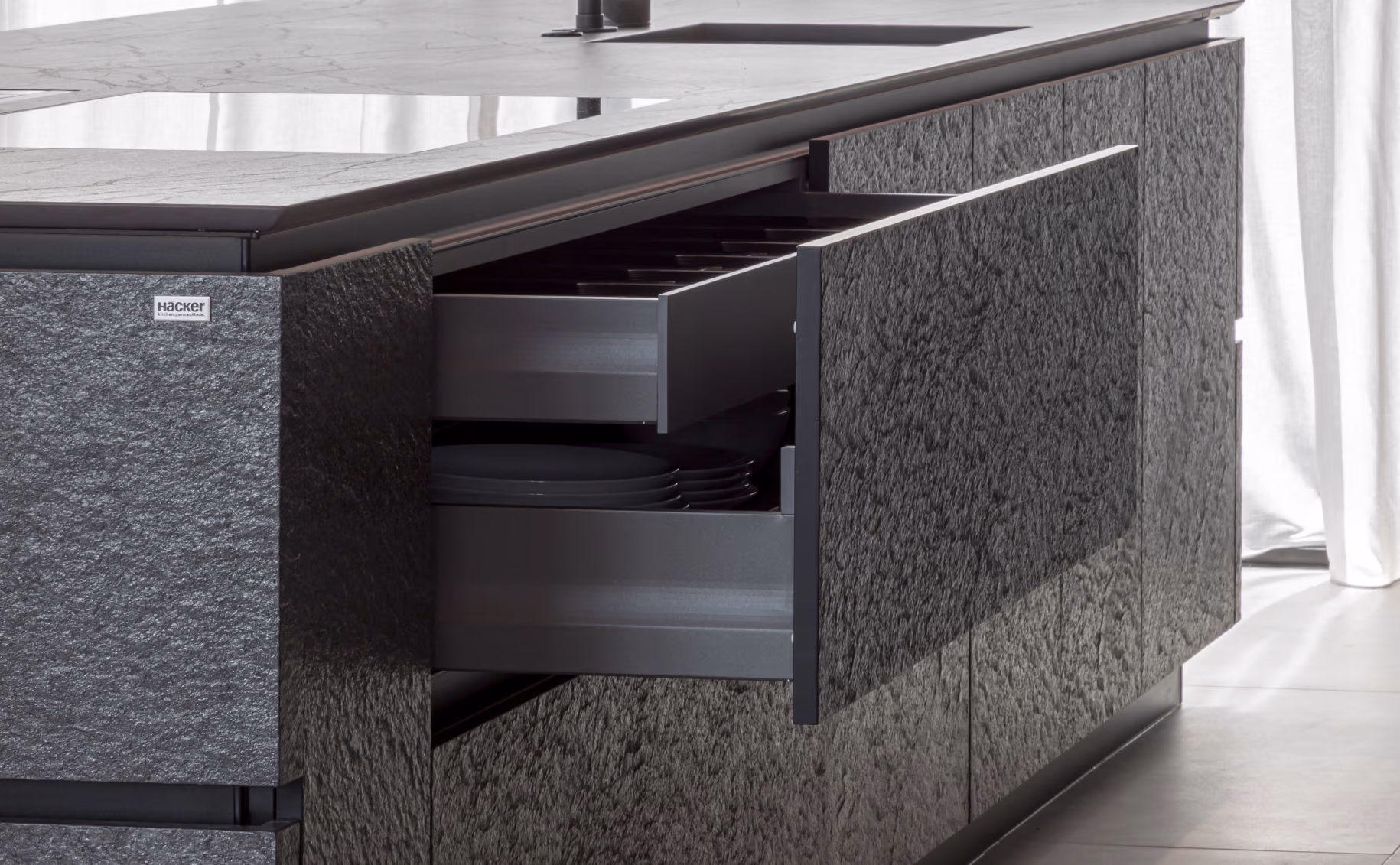 Inner drawer nested inside a deeper drawer in dark stone-finish cabinetry
